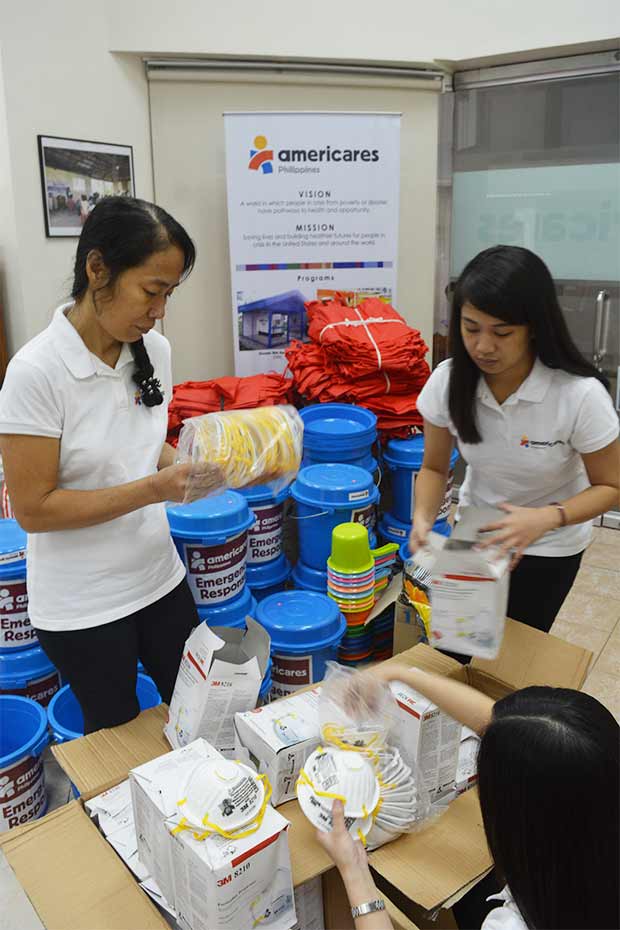 Americares relief workers pack protective masks to send to families staying in evacuation centers in Albay province.