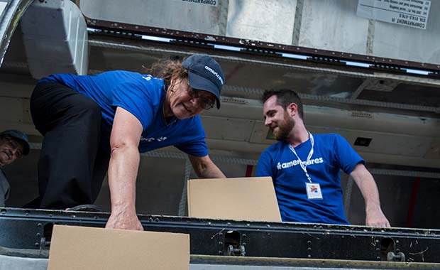 Americares Senior Vice President of Global Programs Dr. E. Anne Peterson helps unload a planeload of medicine and supplies by hand in San Juan on Oct. 1, 2017. 