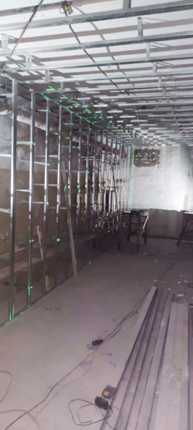 Construction view of metal support framing for storage location. in long narrow room.