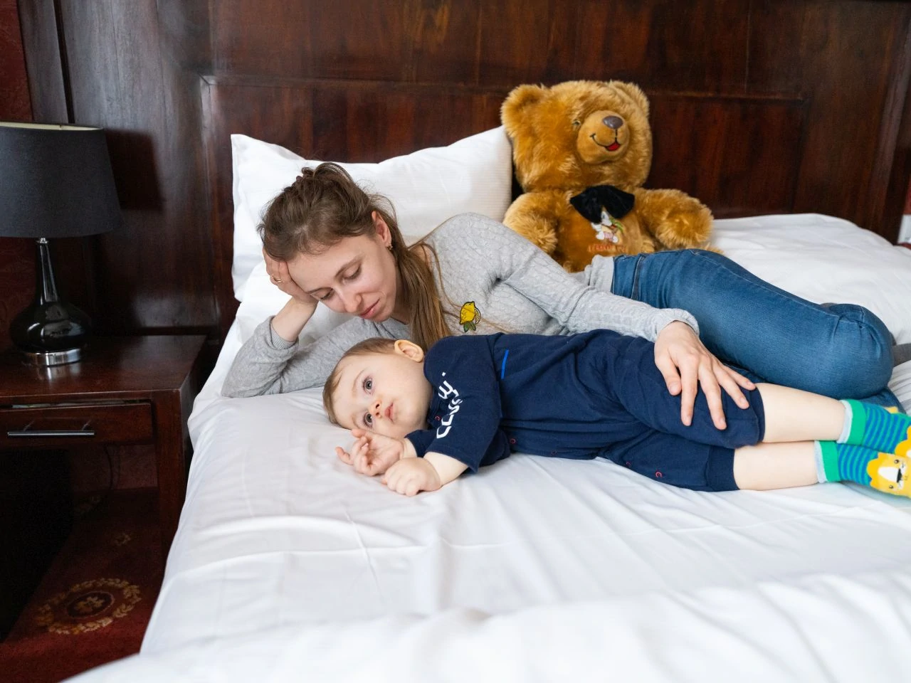 Alina poses for a photo with her son, Timofy, with his new stuffed bear on a bed in a hotel in Krakow, Poland