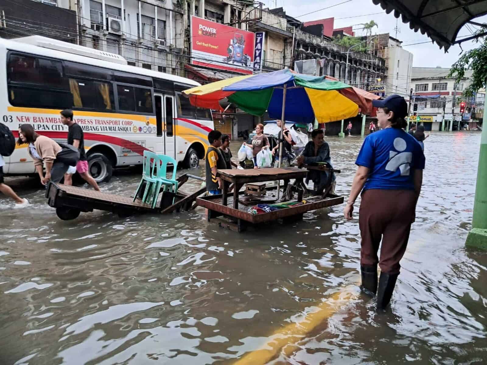 An Americares emergency response team member surveys flooding on streets in Dagupan City, Philippines, after recent typhoons brought torrential rain to the region.