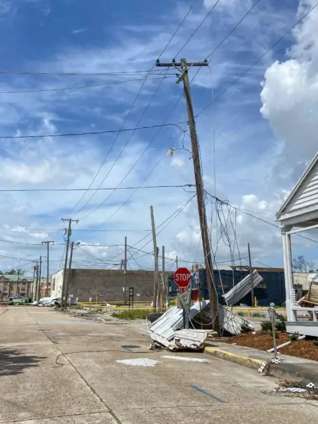 street with utility poles damaged and debris in street