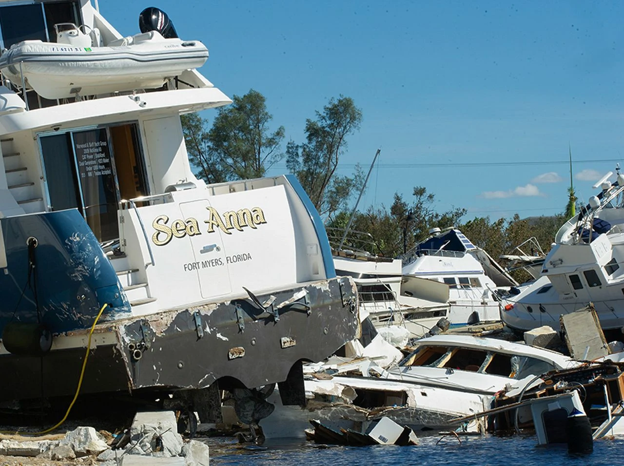 Several boats severely damaged at Fort Myers, Florida waterfront with the Sea Anna boat in the foreground.oats piled in