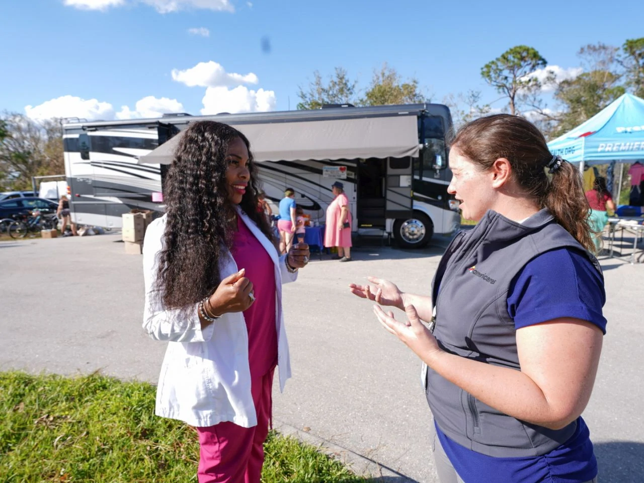 Americares staff member with mobile clinic director in front of the mobile clinic in Fort Myers.