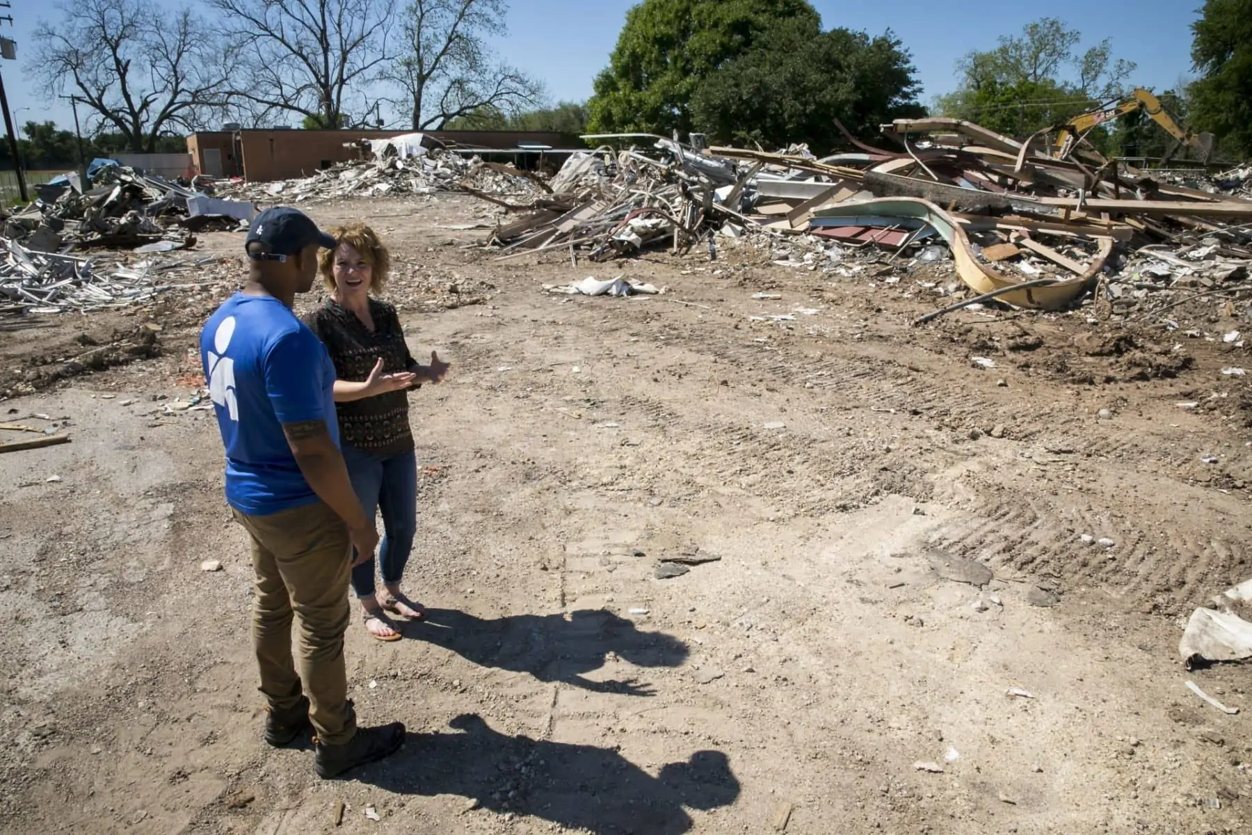 Stephanie Konvicka, who is organizing psychosocial programs for the Matagorda Episcopal Health Outreach Program to help Hurricane Harvey survivors cope with stress and trauma, gives Americares relief worker Curtis Barnes a tour of the storm recovery in her hometown of Wharton, Texas. Here they observe the demolition of the Just Do it Now community center, which was badly damaged in the storm. Konvicka is organizing yoga and art therapy classes to help community members come together and heal with funding from Americares Hurricane Harvey Recovery Program.