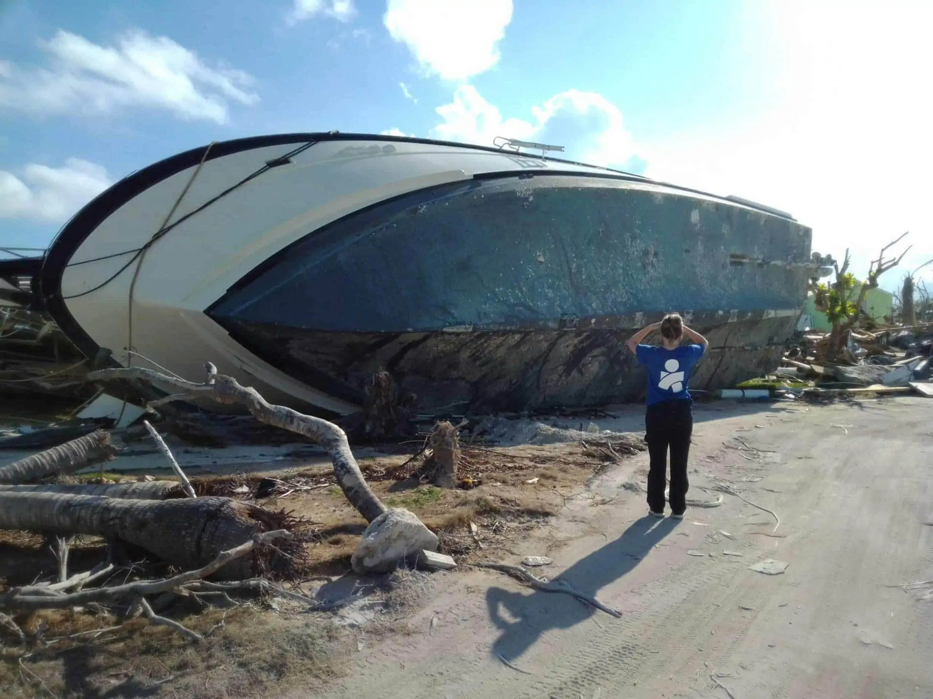 Bahamas Hopetown Americares worker looks at debris and boat damage