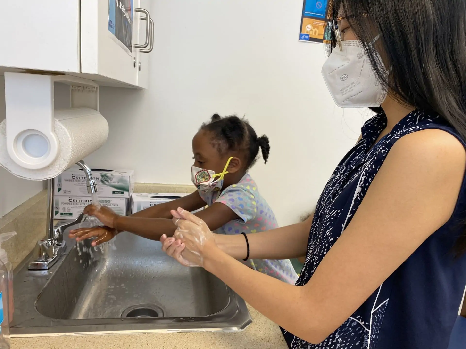 With a mask donated by Americares, Nurse Samatha Tang makes a full safety demonstration at Community of Advanced Practice Nurses clinic in Atlanta, Georgia.
