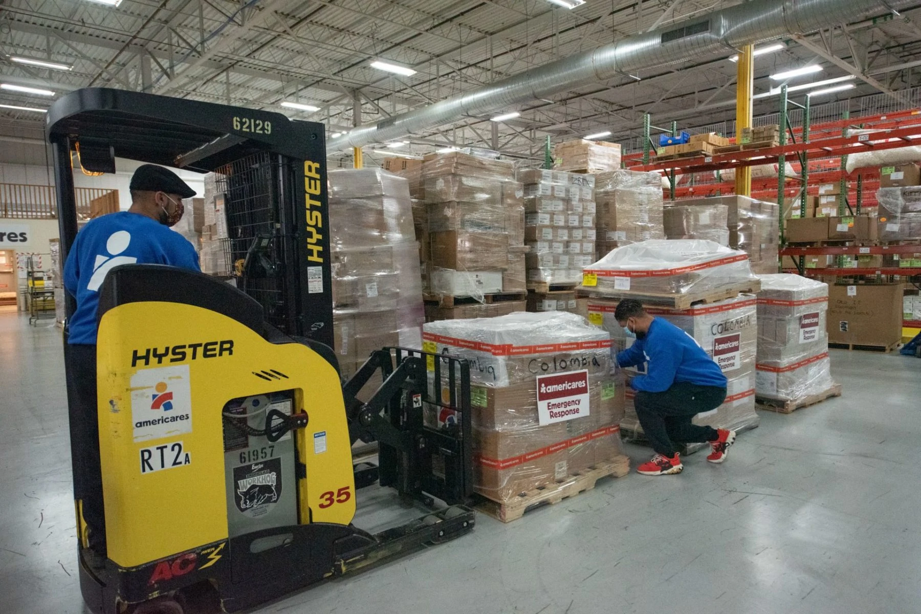 Two Americares staff members prepare an emergency shipment of PPE and hygiene supplies for shipment to Colombia from the Distribution Center.