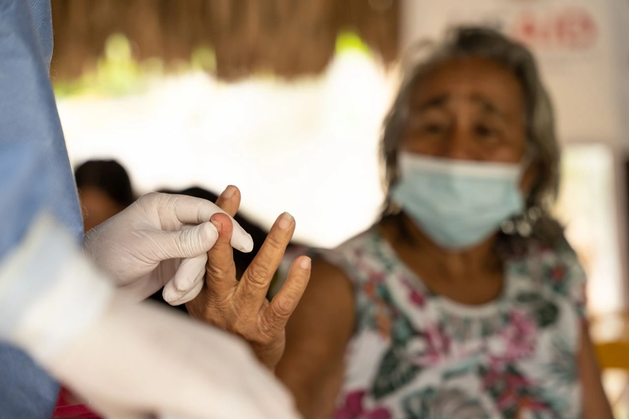 An elderly patient receiving treatment from a health care worker