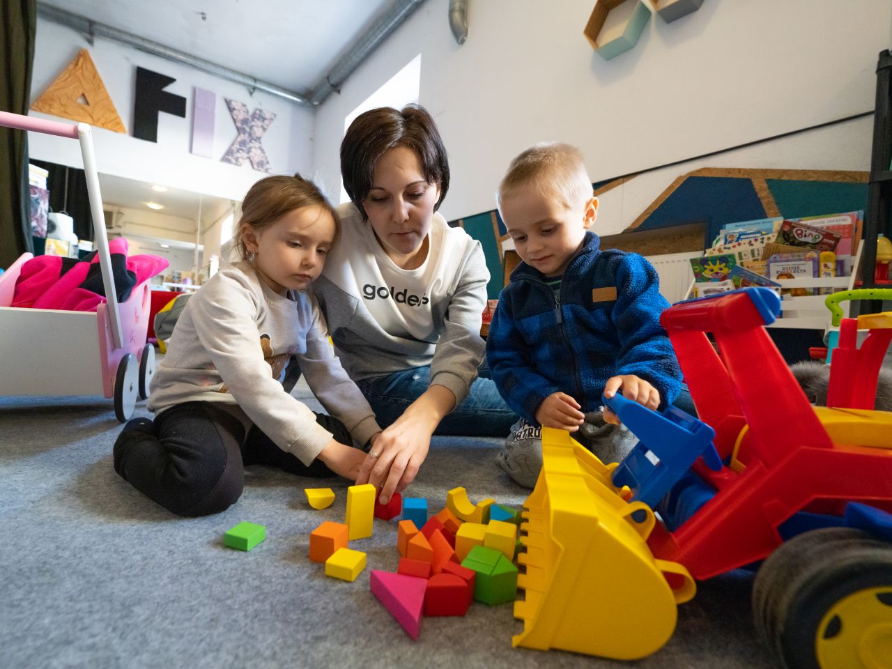 A mother and her children play together in a safe space operated by the Jewish Community Center of Krakow