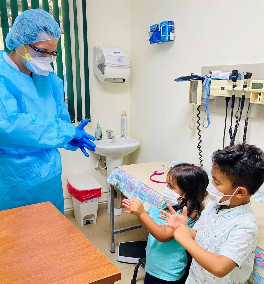 A health worker at Americares Family Clinic in Santiago de María, San Salvador, teaches two young patients how to wash their hands.