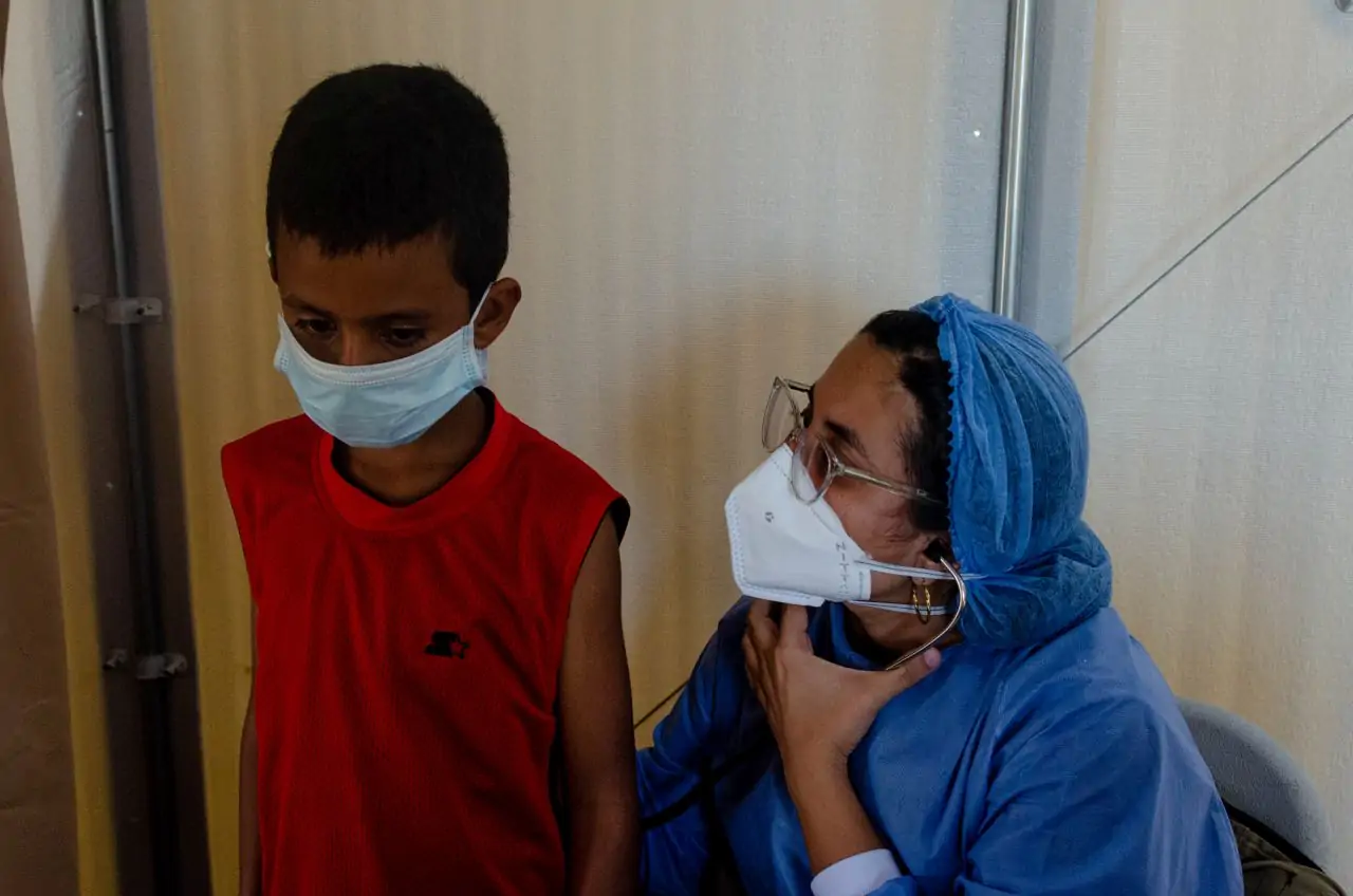 Lisbeth's son with a health care worker at Americares mobile clinic 