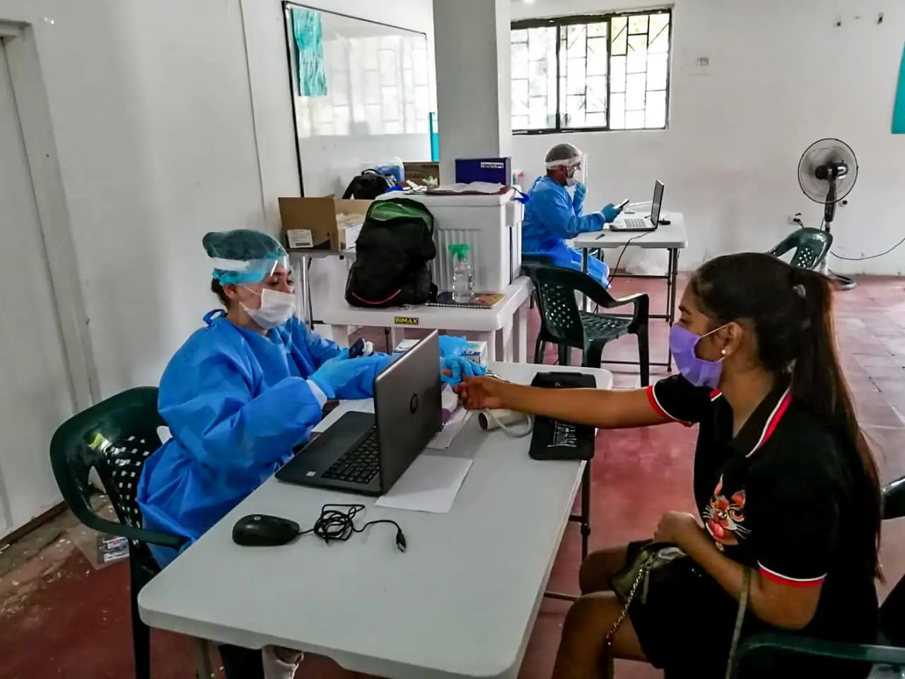 Head nurse interviewing patient sitting at a table in Colombia clinic