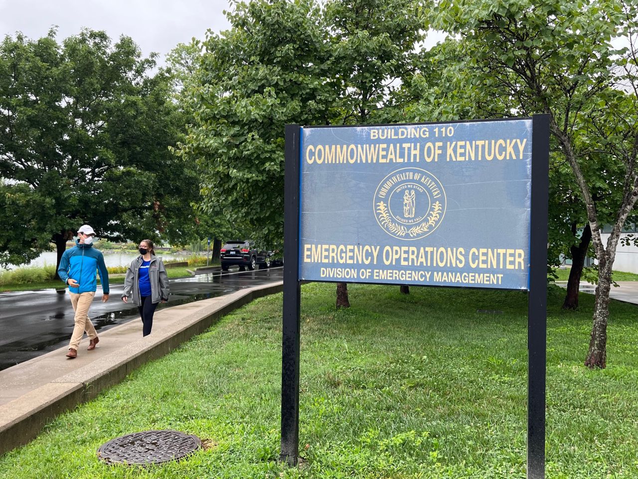 Two members of Americares Emergency Team walking by sign for Kentucky Emergency Operations Center.