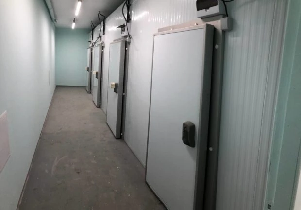 Finished room with four special doors on the right side of the long hallway to be used for safe storage of cancer drugs