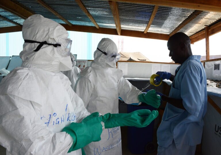 Health workers don personal protective equipment at an Ebola treatment unit supported by Americares in Liberia in 2015. Photo by Alex Ostasiewicz/Americares.