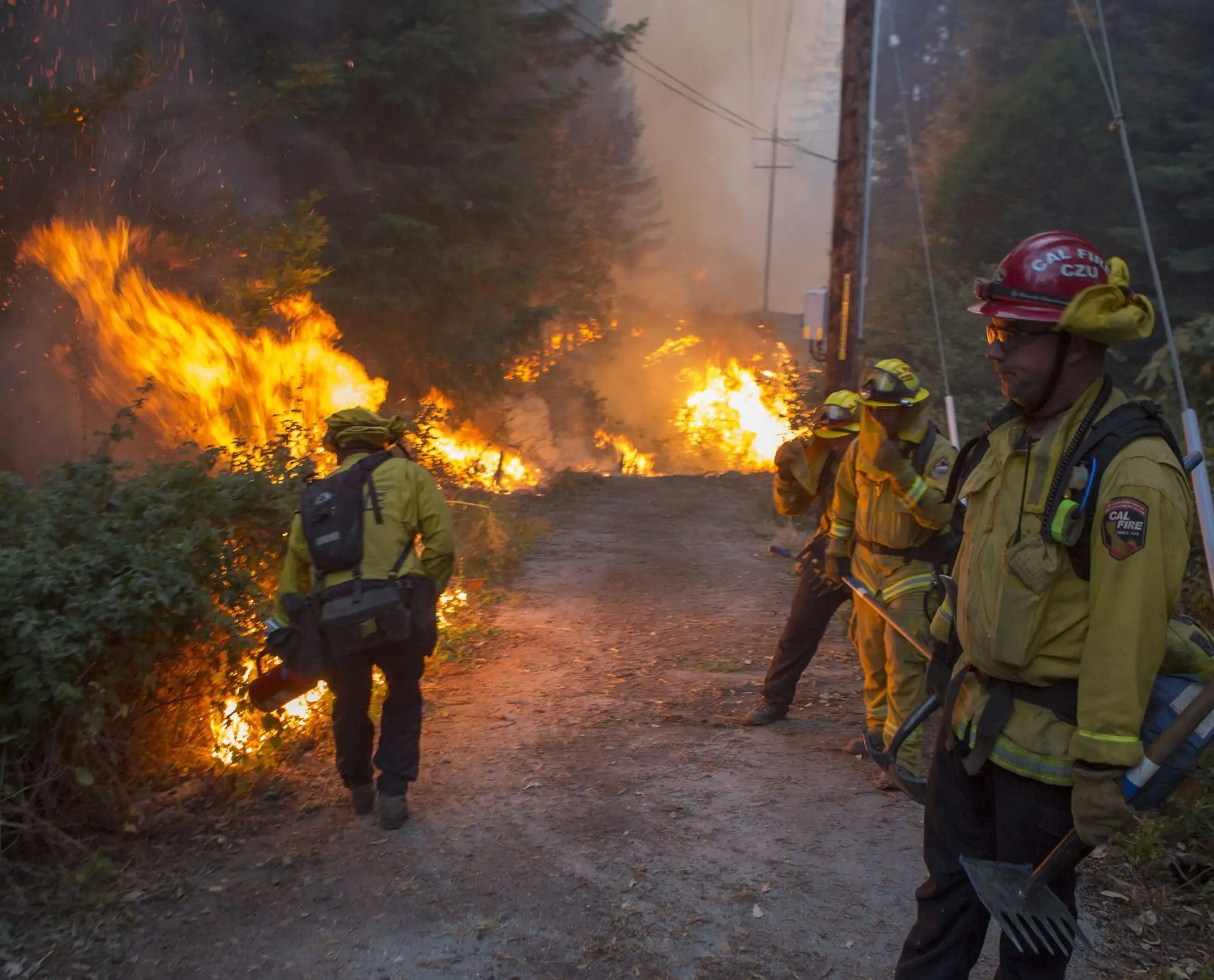 CalFire firefighting team sets a backfire along a dirt road.