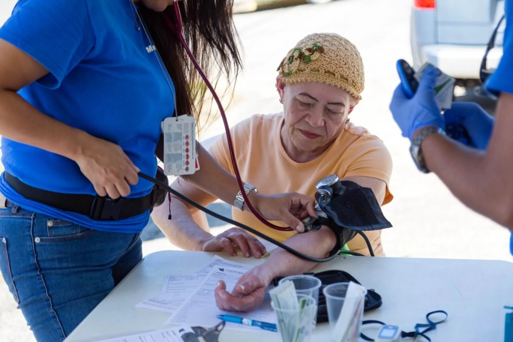 Relief worker takes blood pressure in an outdoor clinic in Puerto Rico