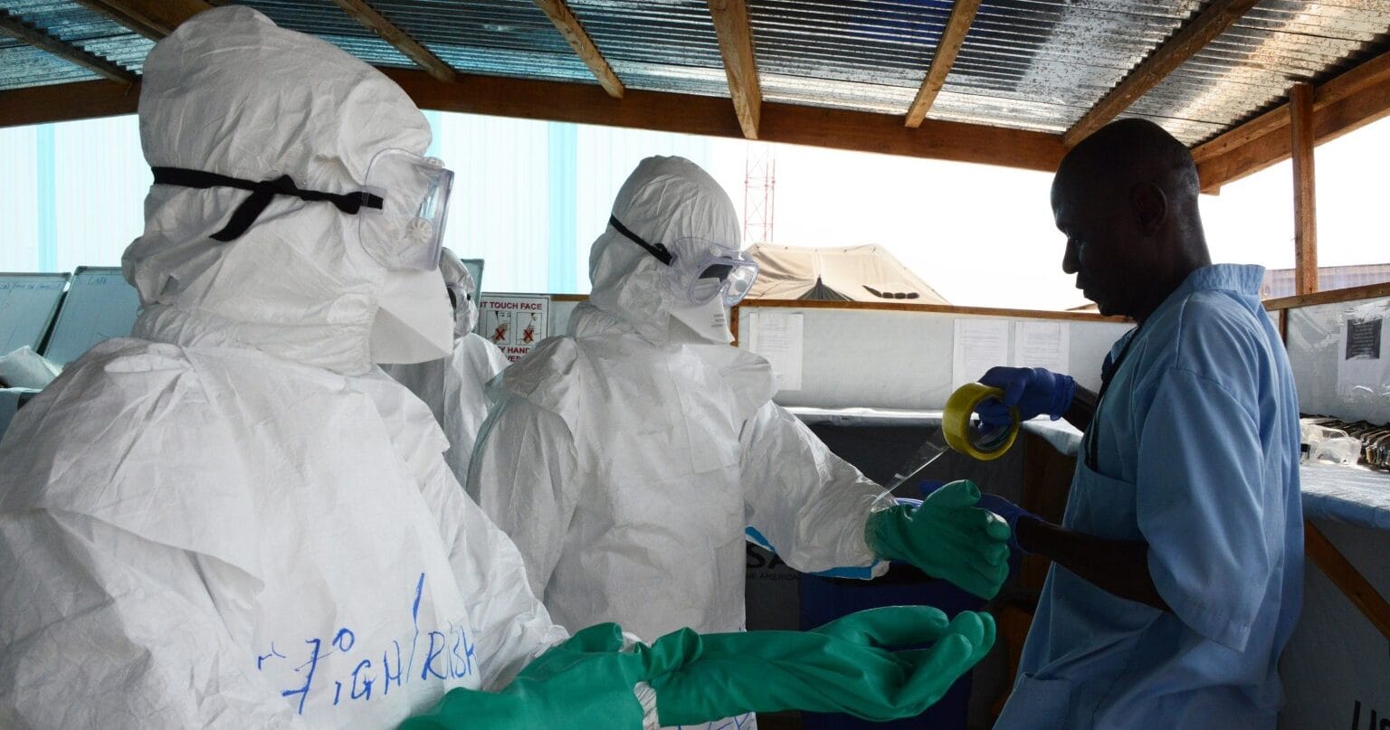 Health workers don personal protective equipment at an Ebola treatment unit supported by Americares in Liberia in 2015. Photo by Alex Ostasiewicz/Americares.