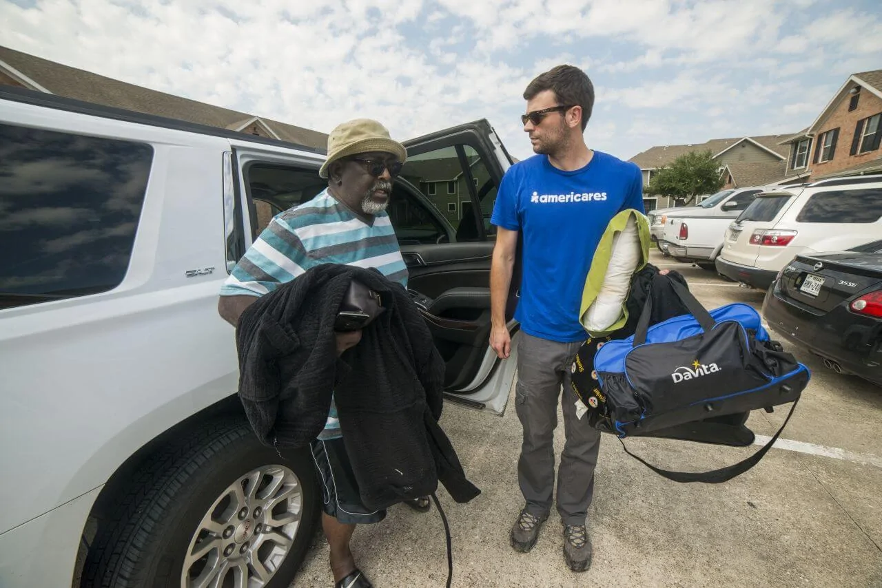 Americares worker helps a man out of an SUV