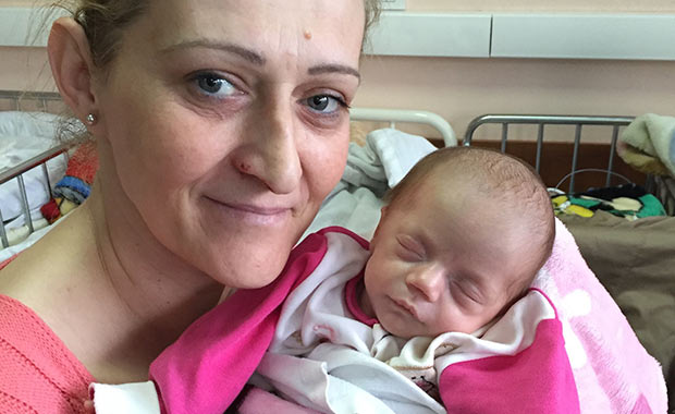 A mother with her newborn daughter treated with surfactant from AmeriCares and AbbVie at the University Clinical Center Kosovo’s Neonatal Intensive Care Unit.