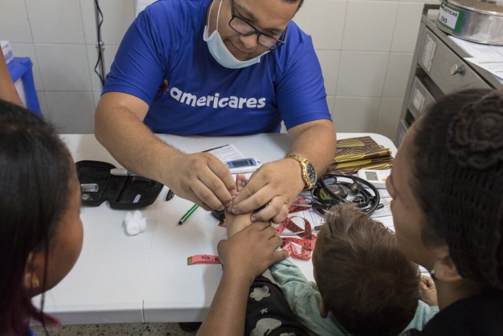 A doctor attends a child at the external consultation headquarter. Americares responds to people’s needs by offering people basic medical aids in a recovered area of the old hospital of Maicao, La Guajira, Colombia, on July 5th, 2018. Children and pregnant mother receive the attention first. Since 2015 Venezuelans' mass migration to Colombia progressively increased. After crossing the border migrants start a long path, often by walk and lasting over three months, to Peru, Chile and Brazil in search of a new life and job opportunities, fleeing their country as President Nicolas Maduro consolidates autocratic power and food and medicine run out due to corruption. Americares is working on the health emergency response. Photographer: Nicolo Filippo Rosso/Americares