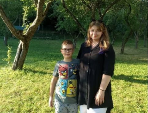 Pavlyna and son posing under a tree.
